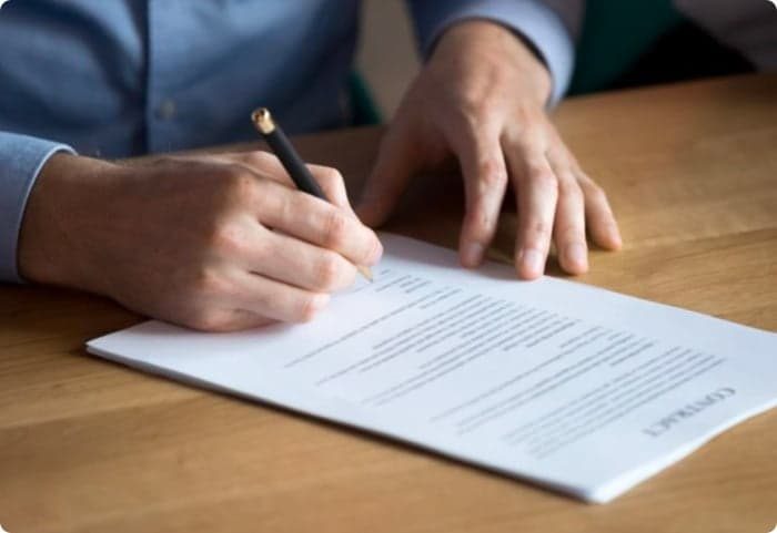 Man Signing Document — Law Firm in Coffs Harbour, NSW
